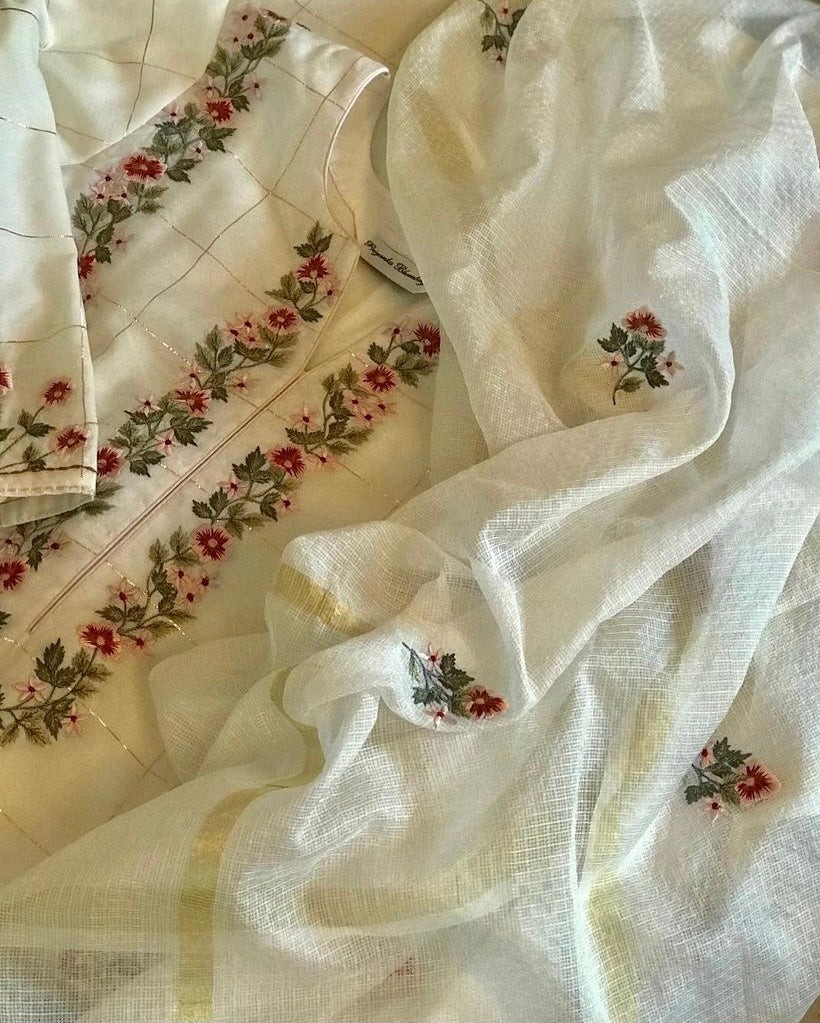 Dainty floral embroidery on a delicately zari woven pure chanderi. The set’s beauty lies in its delicate embroidery and the hint of gold that comes in the weave. Florets on checks - Mulmul And More Luxury by Priyanka Bhambry
