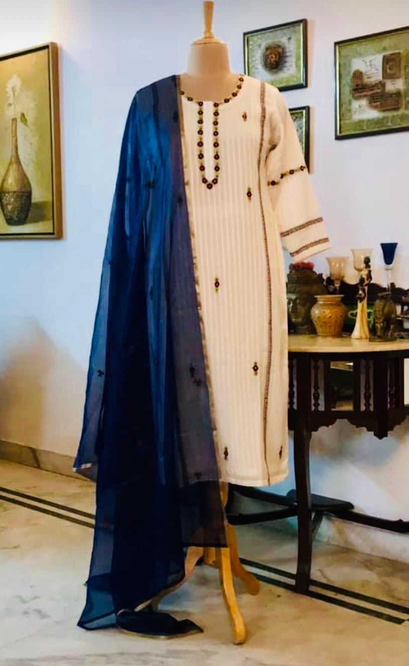 Suit Descrition : The kurta is on Silk Mulmul, it comes with blue stretchable cotton pants and an orgqnza dupatta. the dupatta has tiny roses embroidered all over - Classis Indeed! Mulmul And More by Priyanka Bhambry
