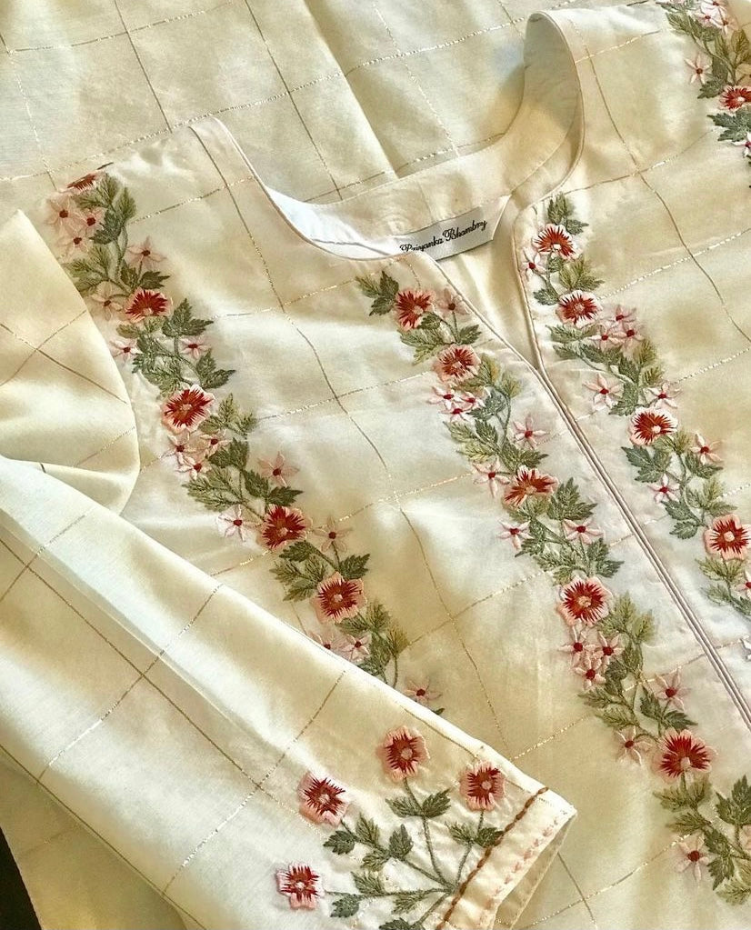 Dainty floral embroidery on a delicately zari woven pure chanderi. The set’s beauty lies in its delicate embroidery and the hint of gold that comes in the weave. Florets on checks - Mulmul And More Luxury by Priyanka Bhambry