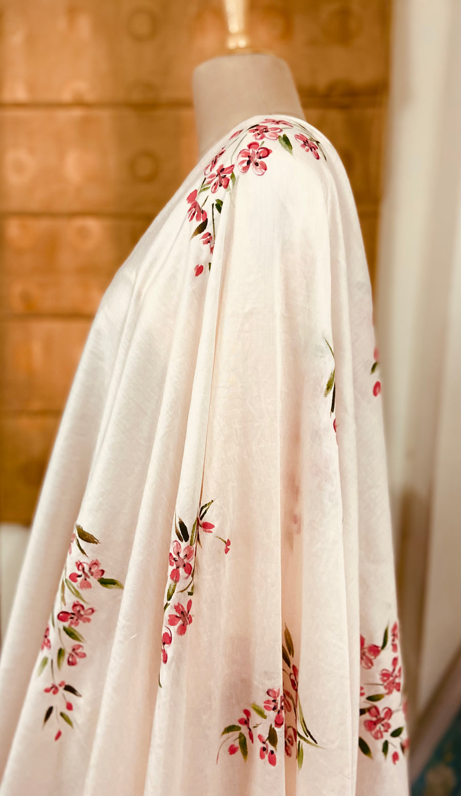 This Lovely suit set is done in pastel peach colour in pure silk chanderi and lined with fine mulmul. The dupatta is also in pure silk chanderi and is handpainted with deep pink daisies all over. Its a three piece suit set.Mulmul And More by Priyanka Bhambry