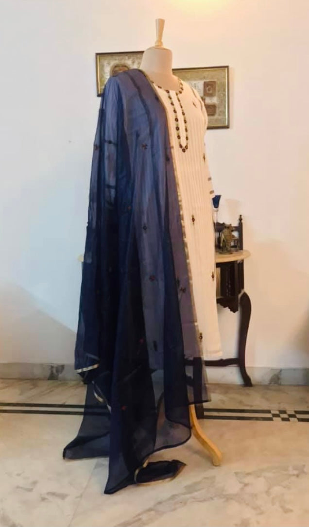 Suit Descrition : The kurta is on Silk Mulmul, it comes with blue stretchable cotton pants and an orgqnza dupatta. the dupatta has tiny roses embroidered all over - Classis Indeed! Mulmul And More by Priyanka Bhambry